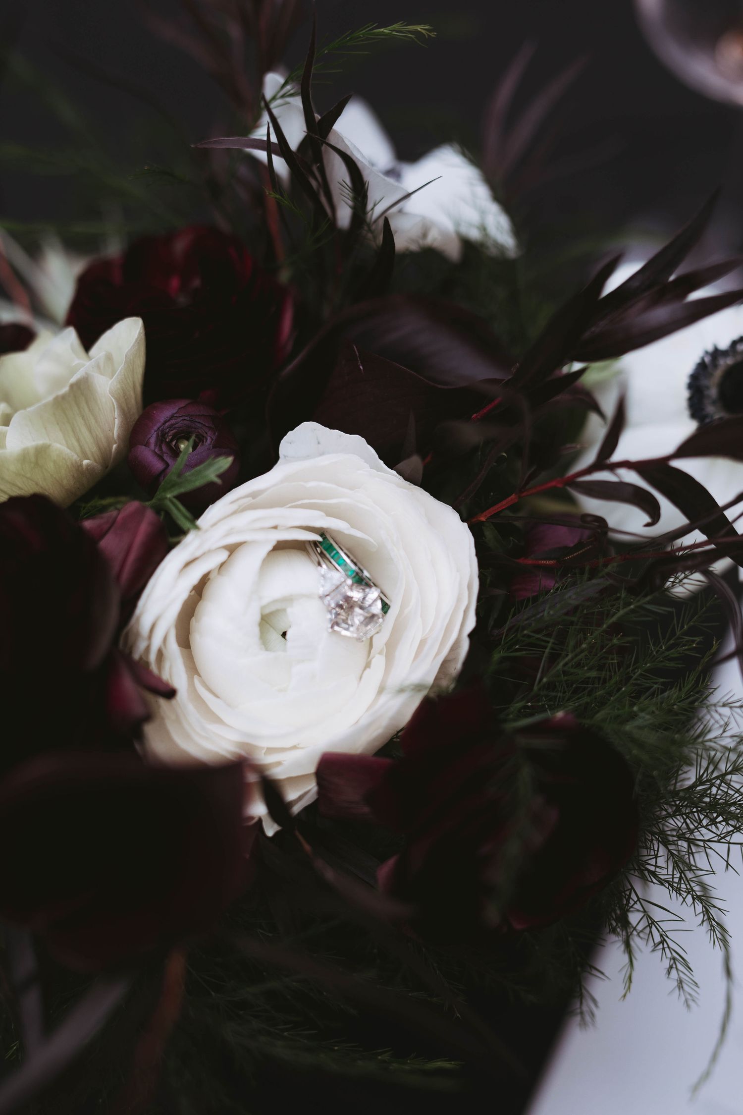 Women's engagement and wedding rings displayed in a white flower