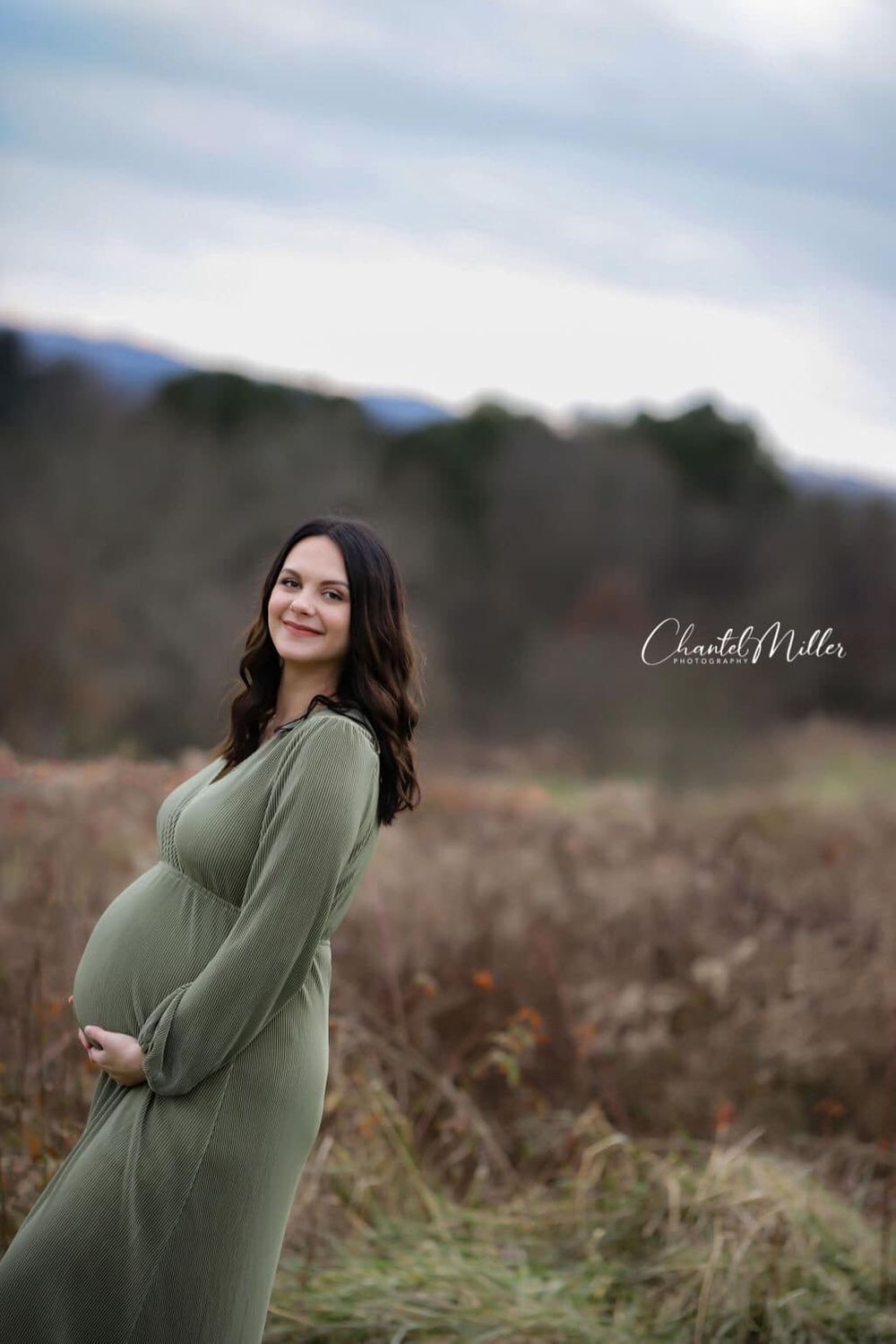 maternity dressed in green holding belly