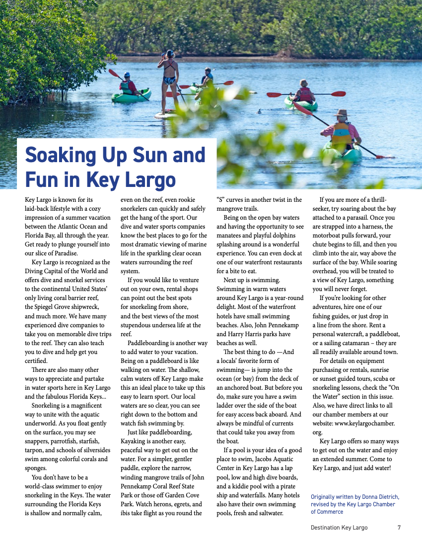 Several kayakers and paddle boarders enjoy water activities on a scenic lake surrounded by lush green trees.