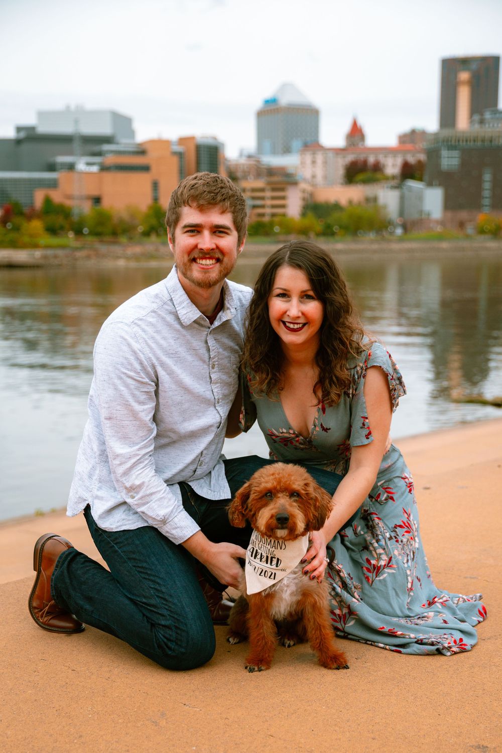 engaged couple with dog with skyline in the background