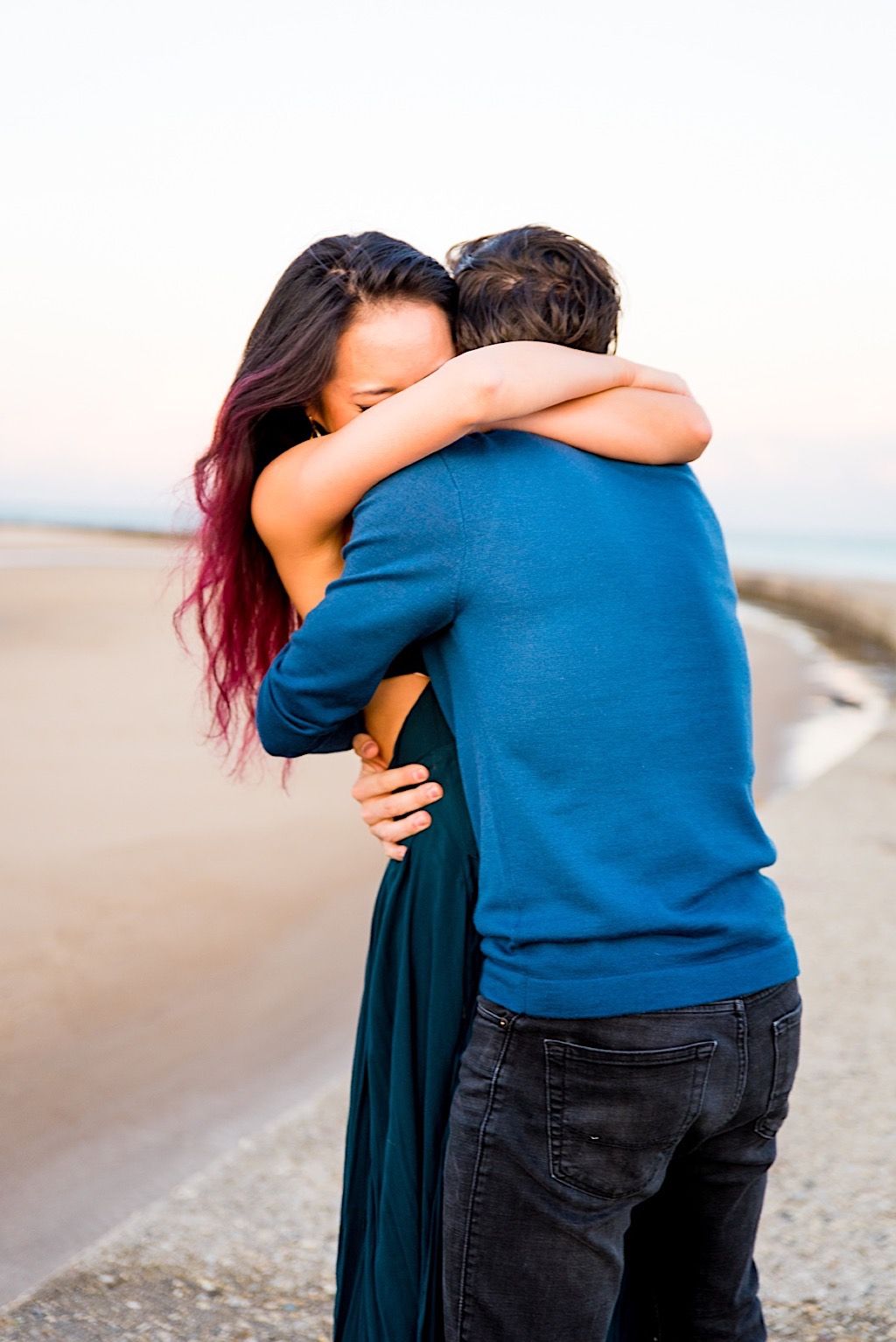 woman in teal tightly hugging her new fiance on North Avenue Beach Chicago