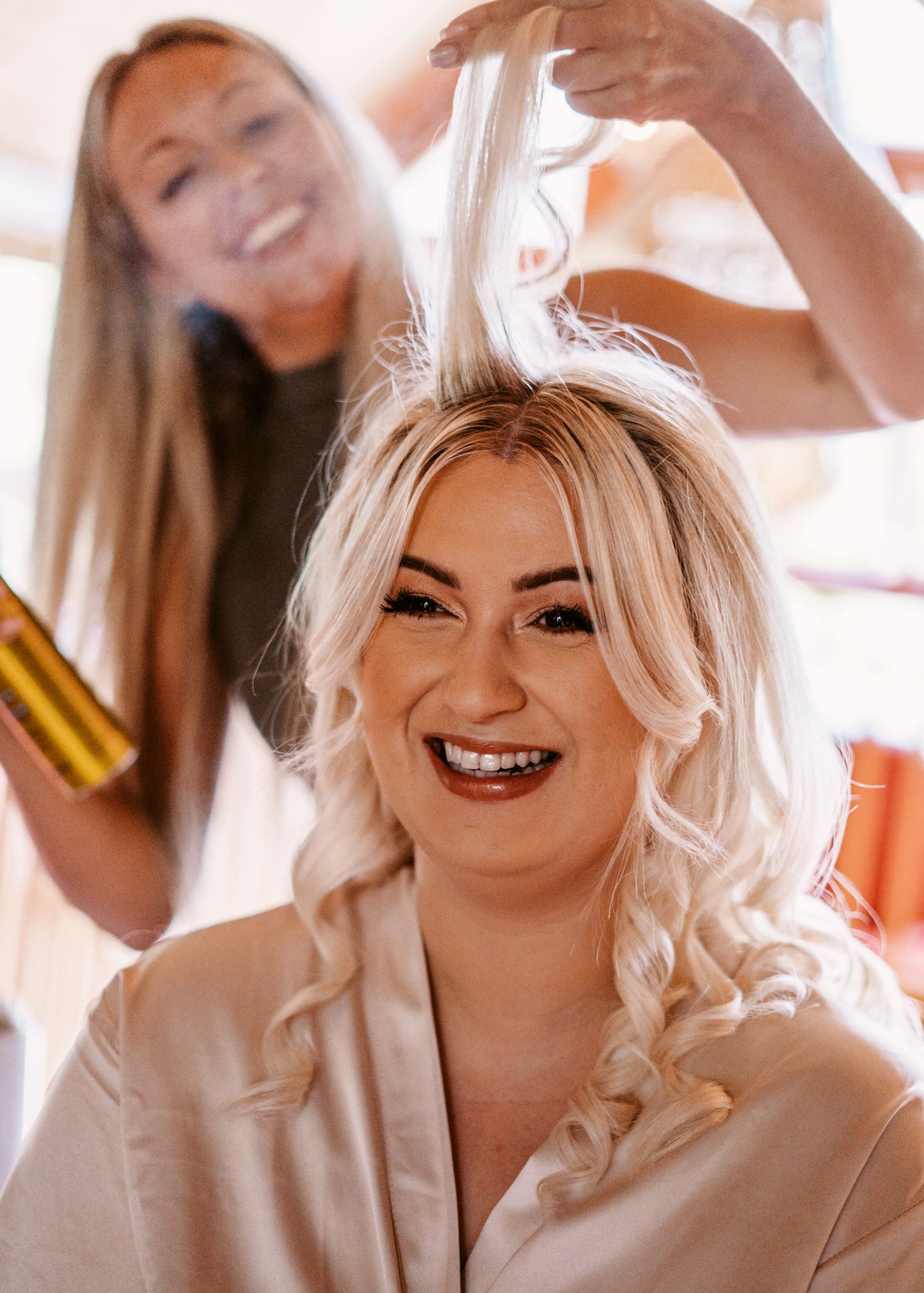bridesmaid having hairspray applied
