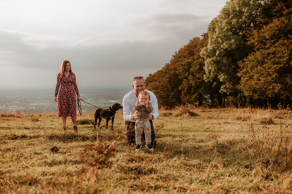 family and their dog at sunset