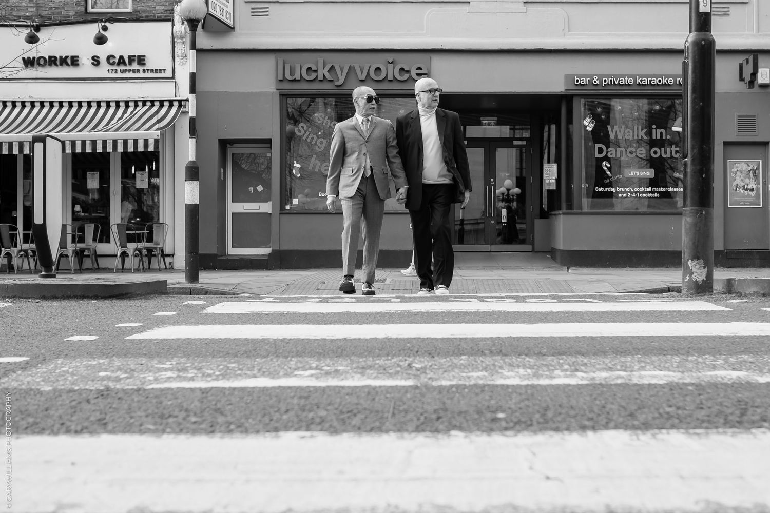 Gay couple walking across a zebra crossing in Islington in London
