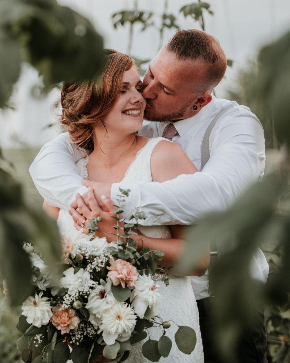 groom kissing brides cheek in the rows of Hops