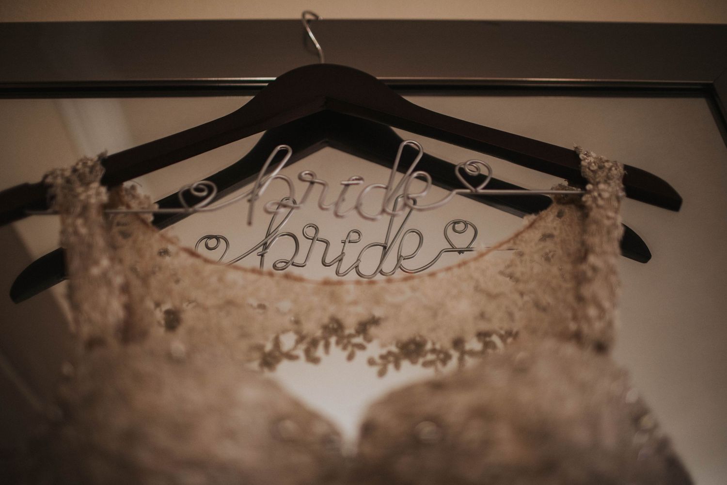 Wedding gown on bridal hanger with wire writing for Greenville, NC microwedding for LGBT couple.