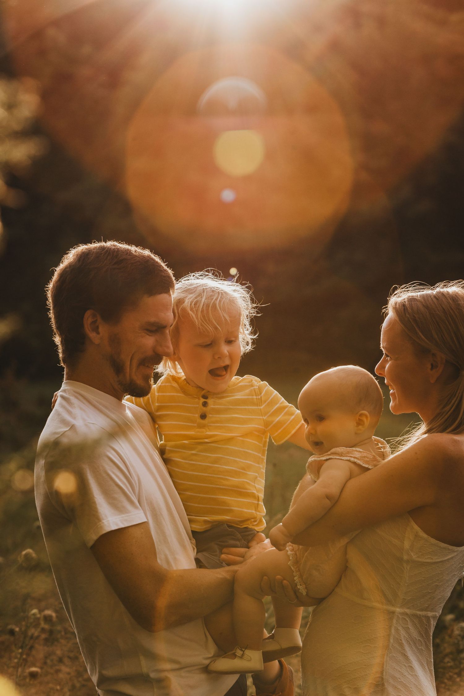 Family enjoying golden hour sunlight together in nature setting.
