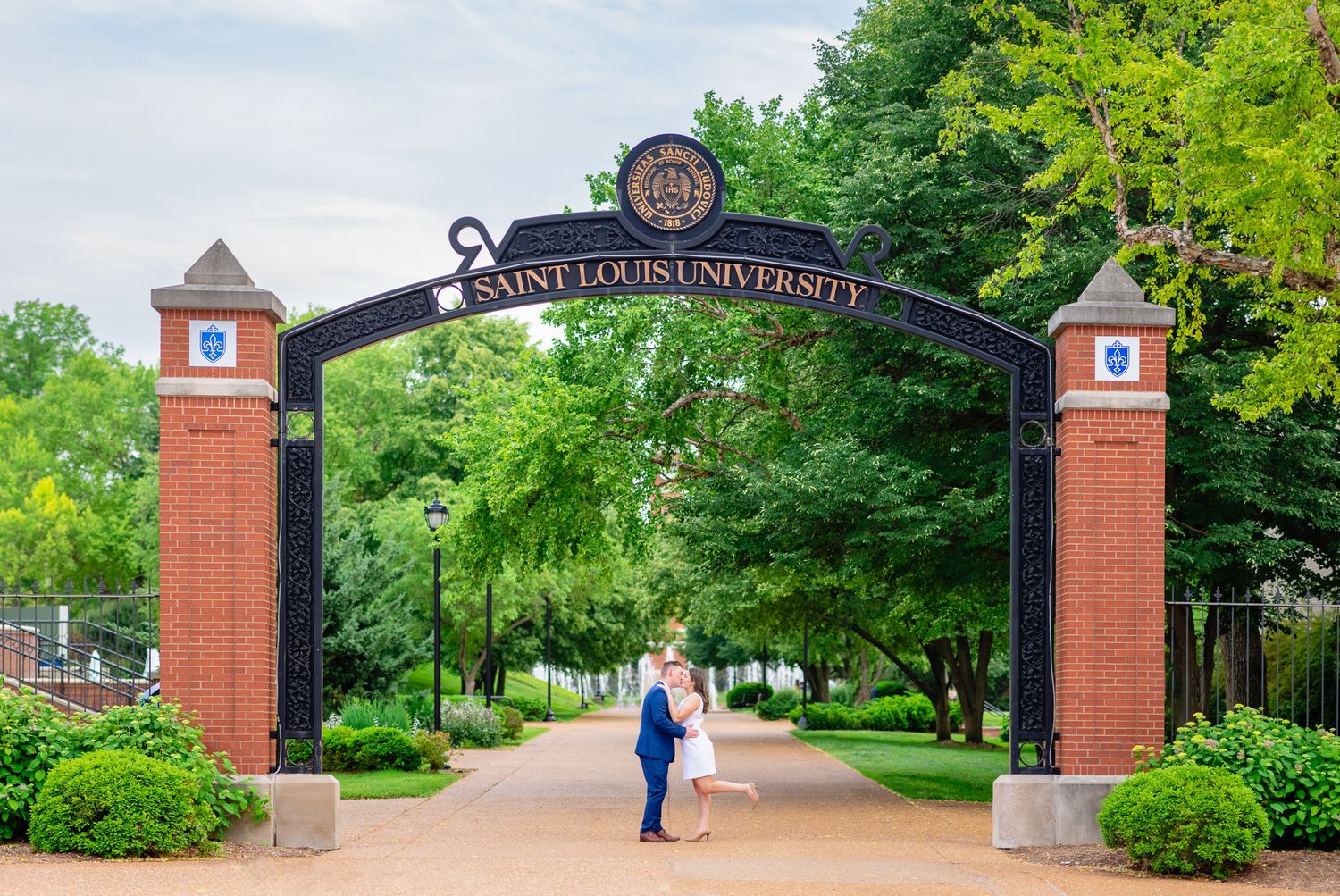 Engaged Couple Kissing Under Arch During Engagement Session