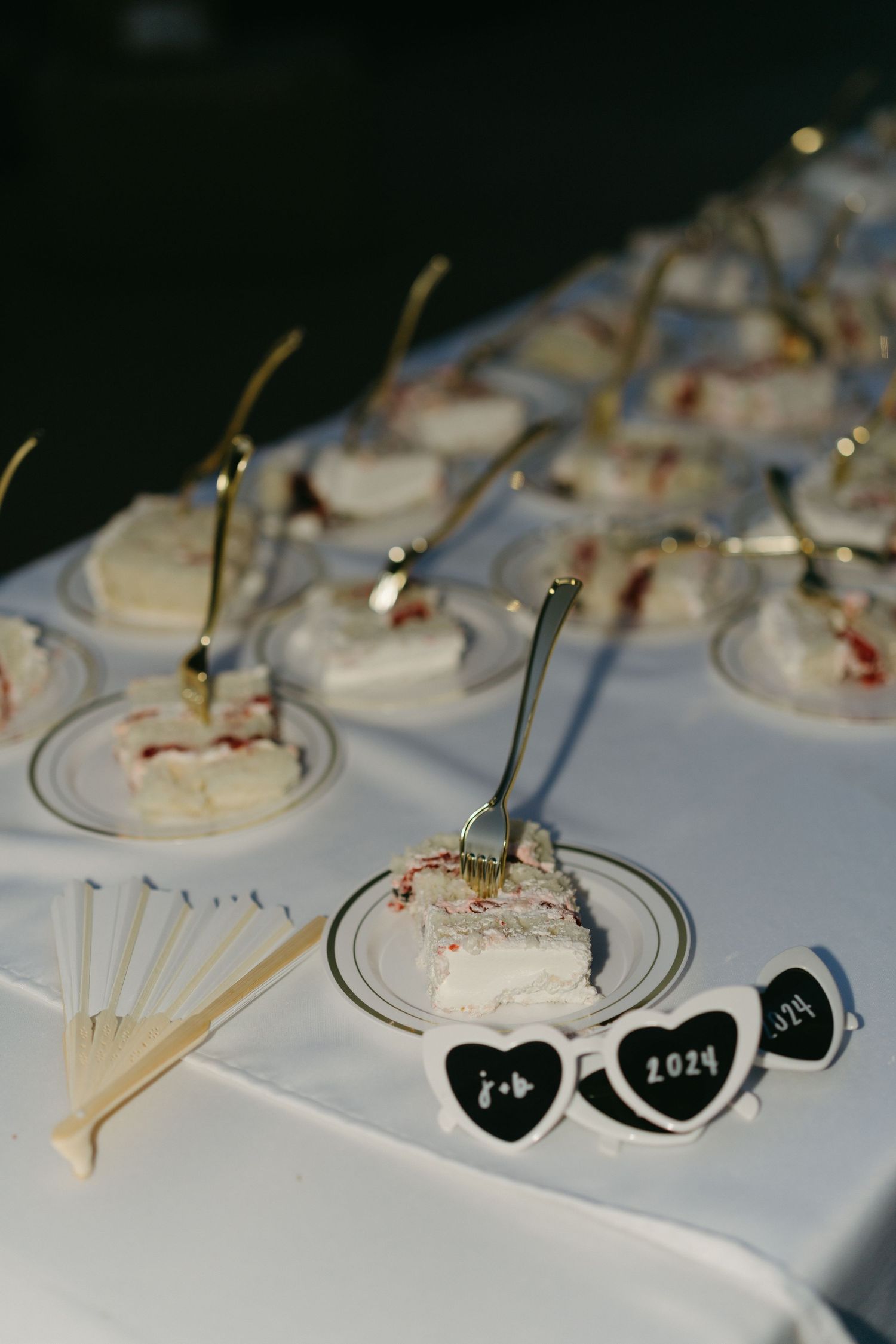 Wedding dessert display with small individual treats decorated with heart-shaped tags.