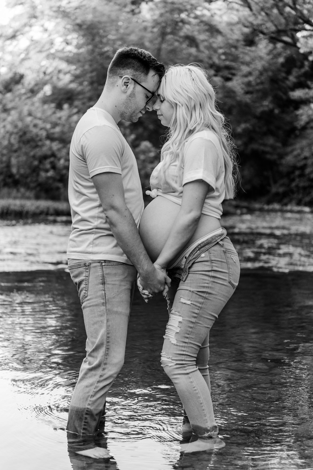 Nontraditional maternity photos in jeans and white shirt in water in Harmony, Pennsylvania