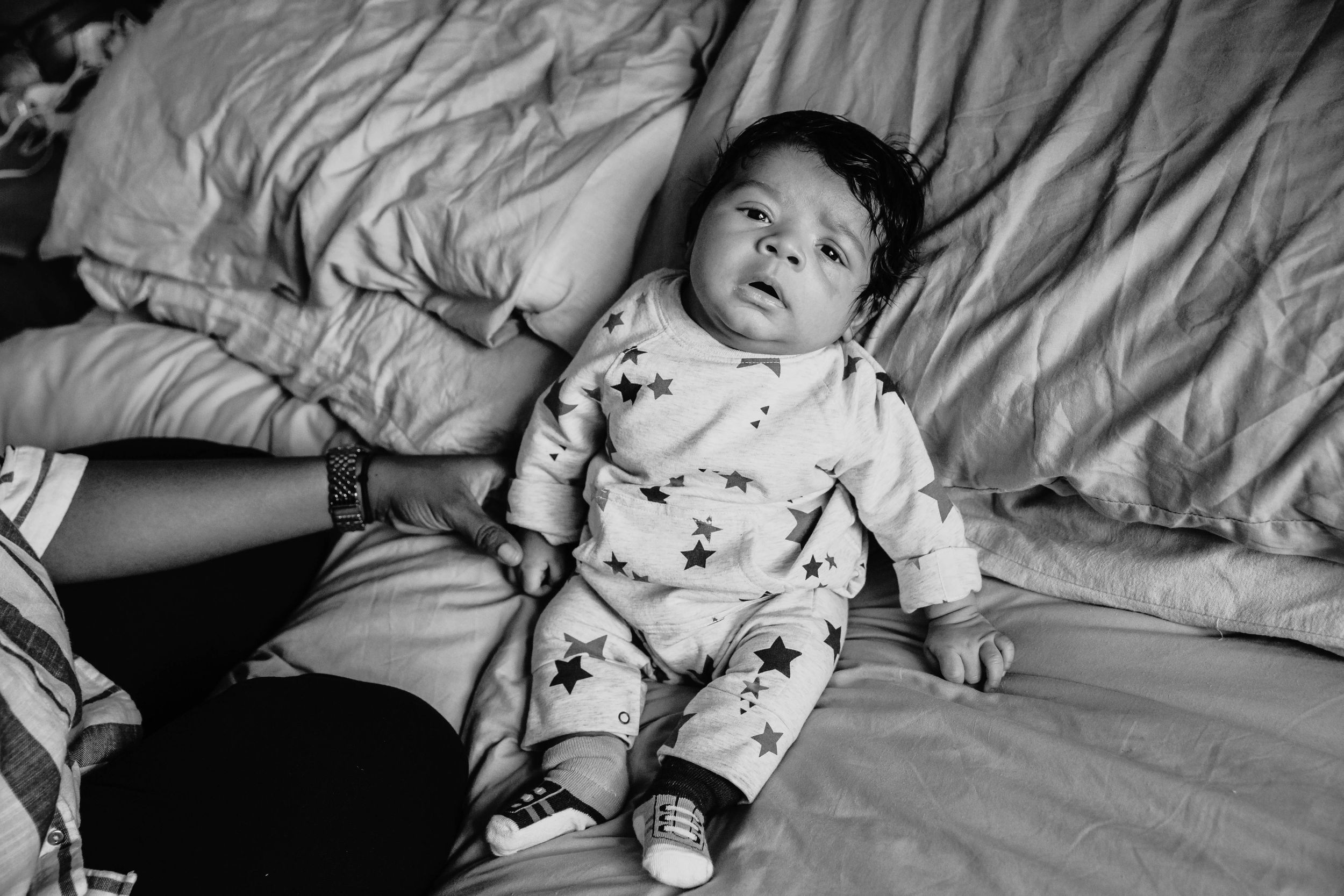 7 week old baby boy sitting on bed