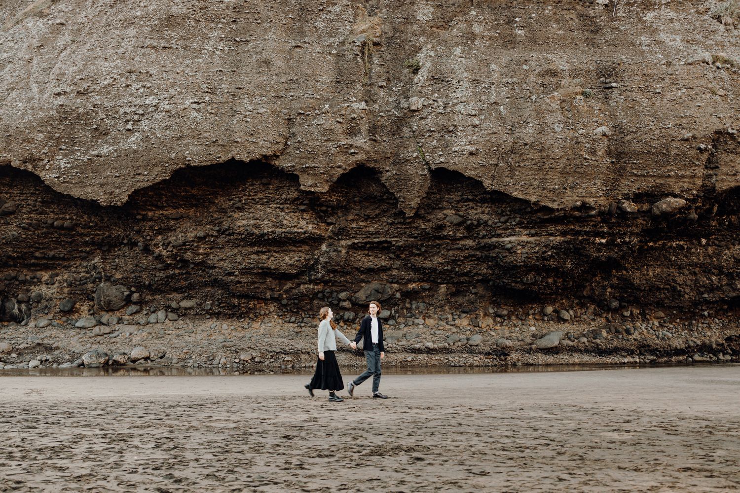 Walking couple for their engagement shoot in Piha with Apertured Media-Auckland Wedding and Elopement Photographer
