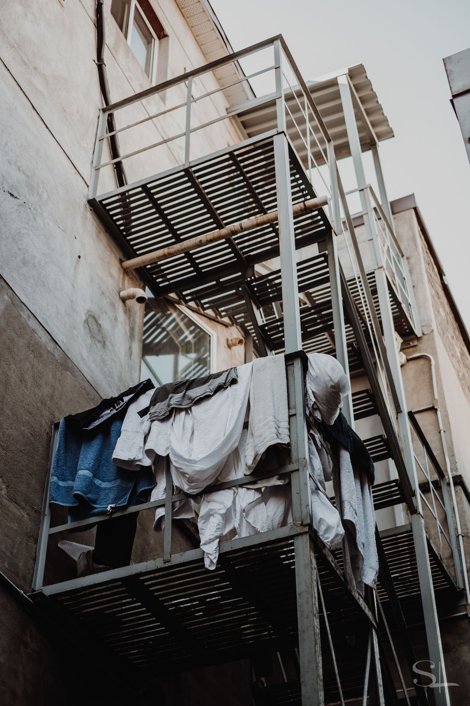 laundry hangs from a back alley fire exit