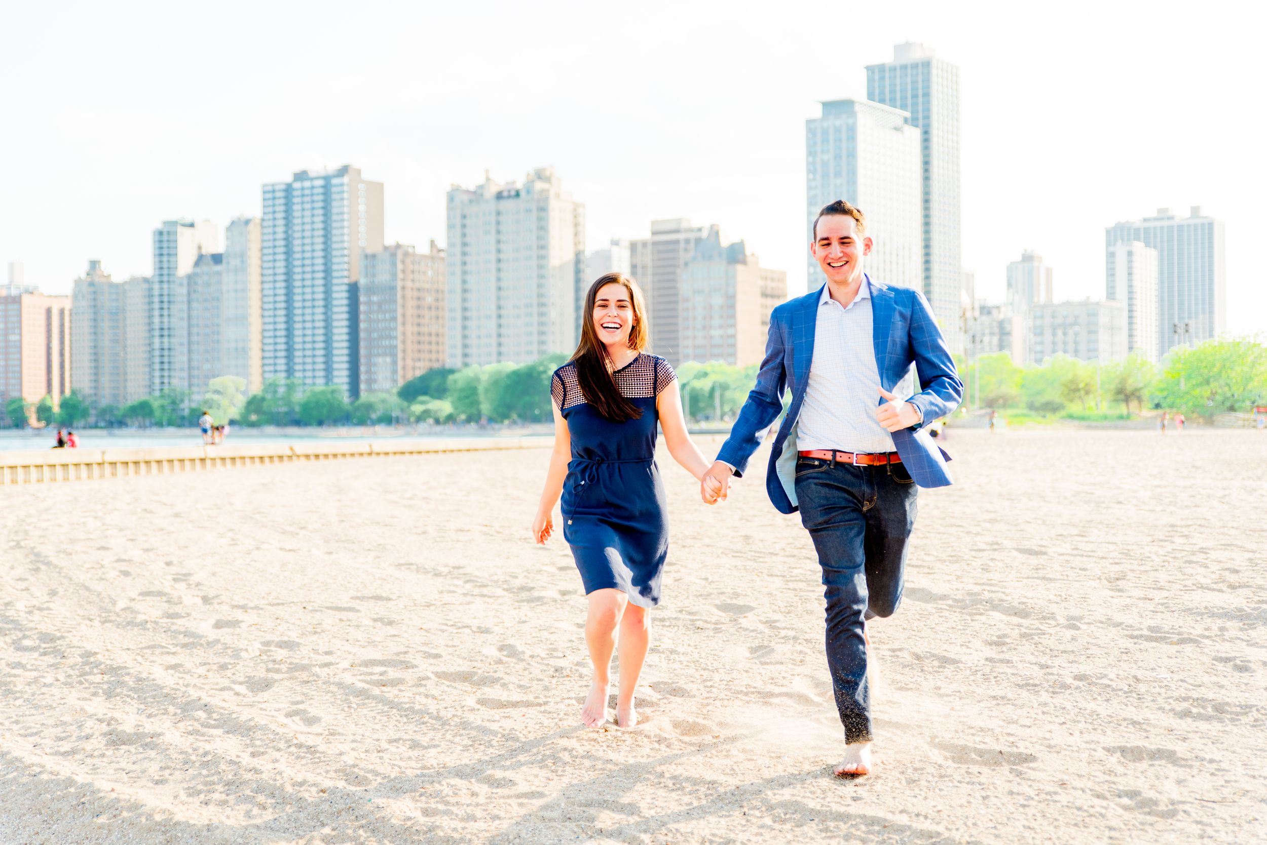 man and woman running along North Avenue Beach after proposal in Chicago