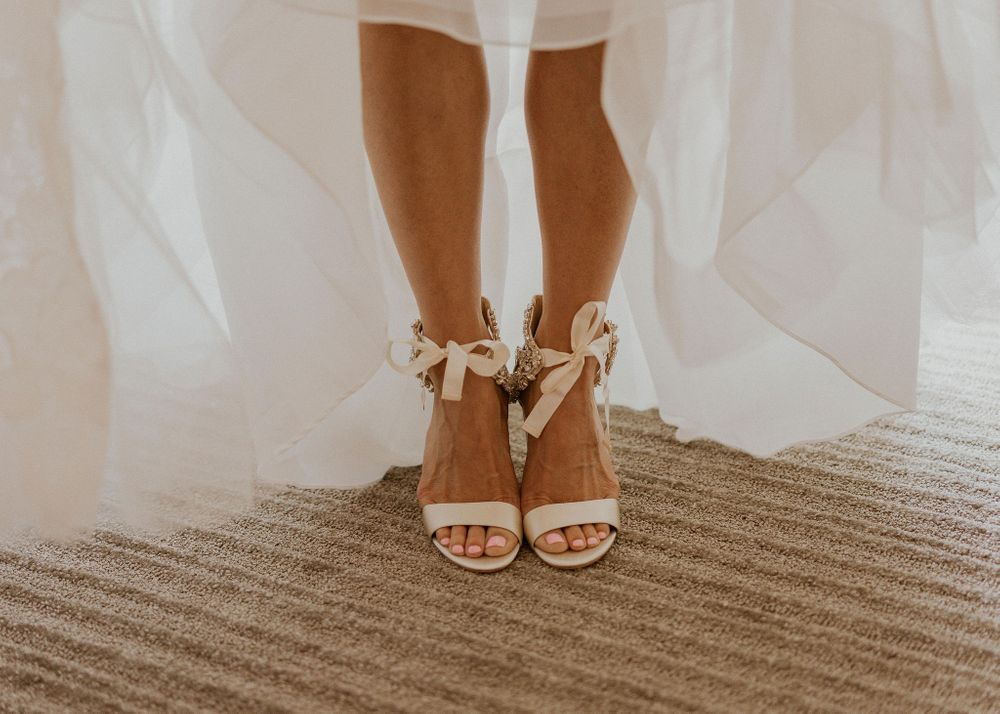 Bride showing off her shoes under the skirt of her dress