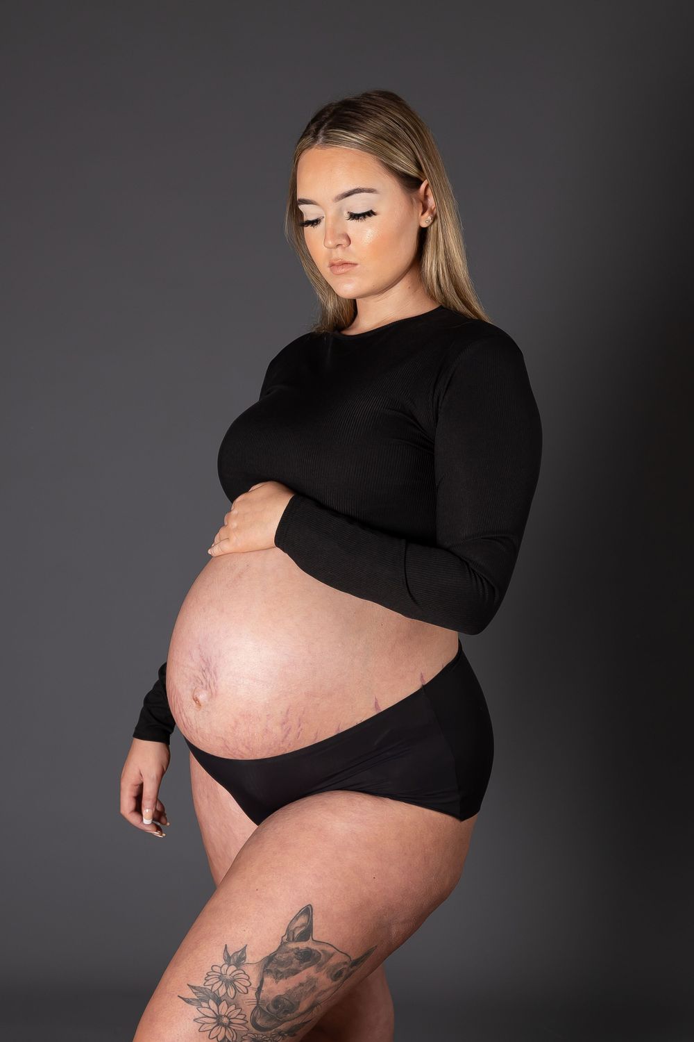 pregnant lady in black short and crop top holding bump