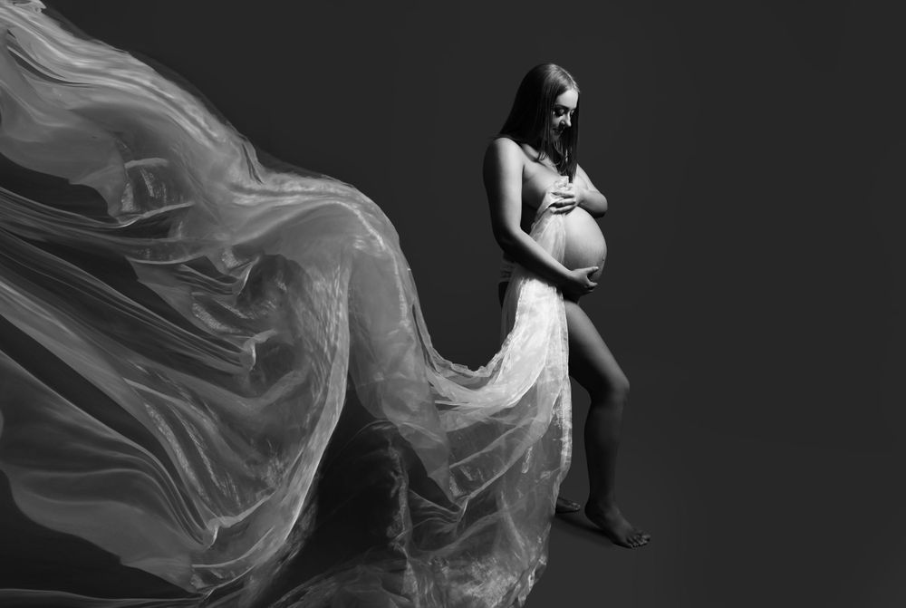 pregnant lady holding material that is flowing picture is black and white