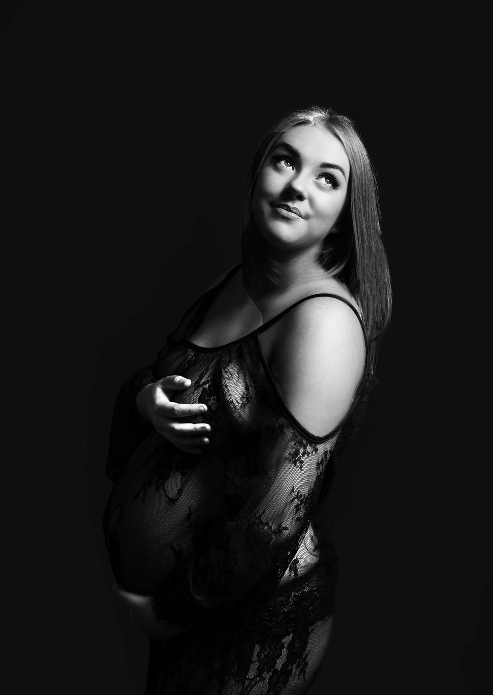 pregnant lady in black lace gown looking over her shoulder