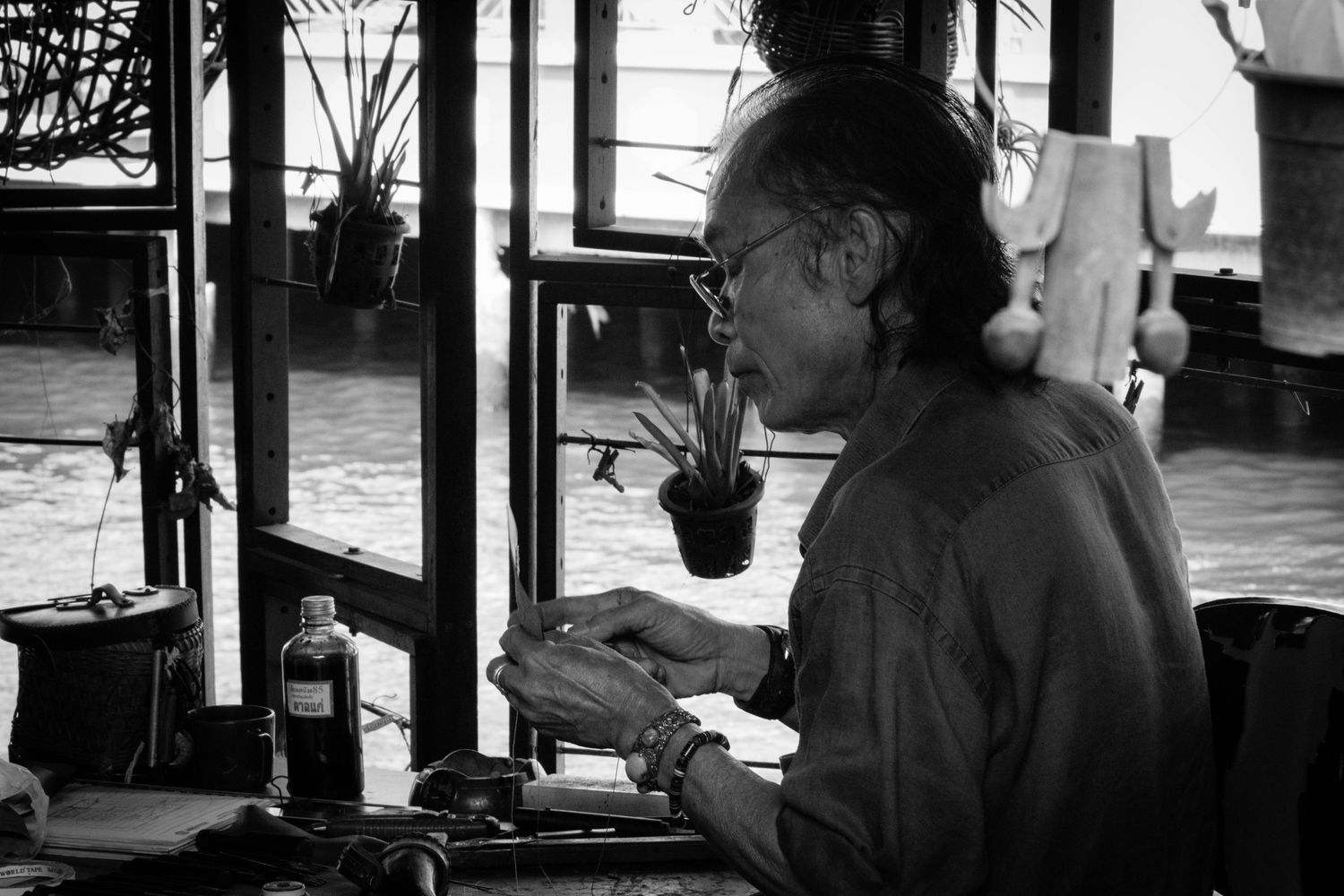 Black and white environmental portrait artist working on canal bank in Bangkok Thailand