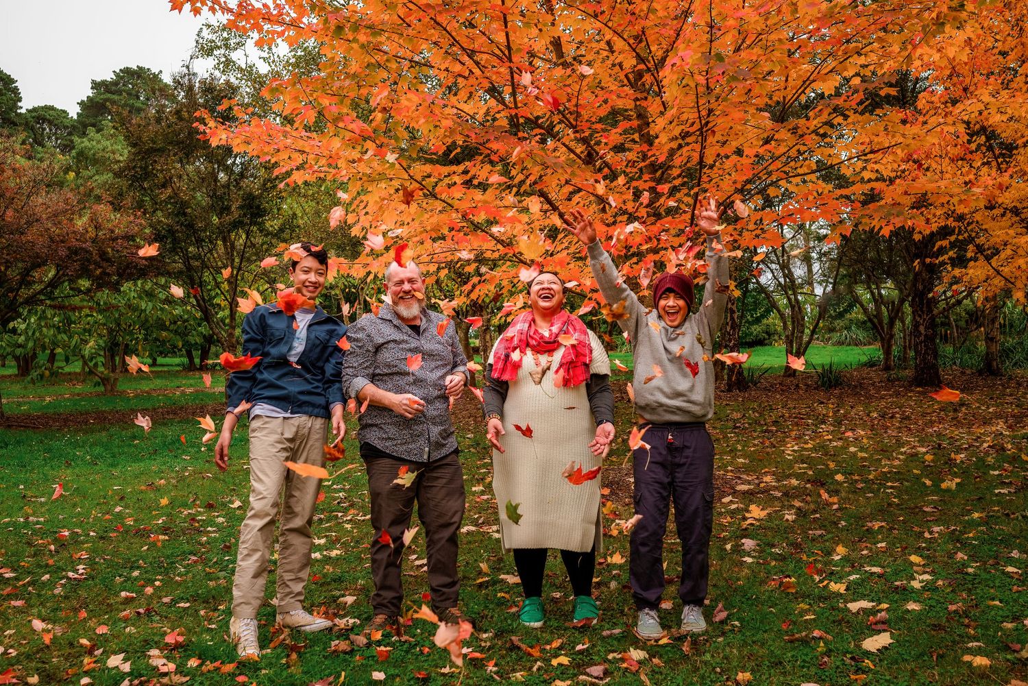 Family of four throwing Autumn leaves in Emerald by Kate Cashin Photography.