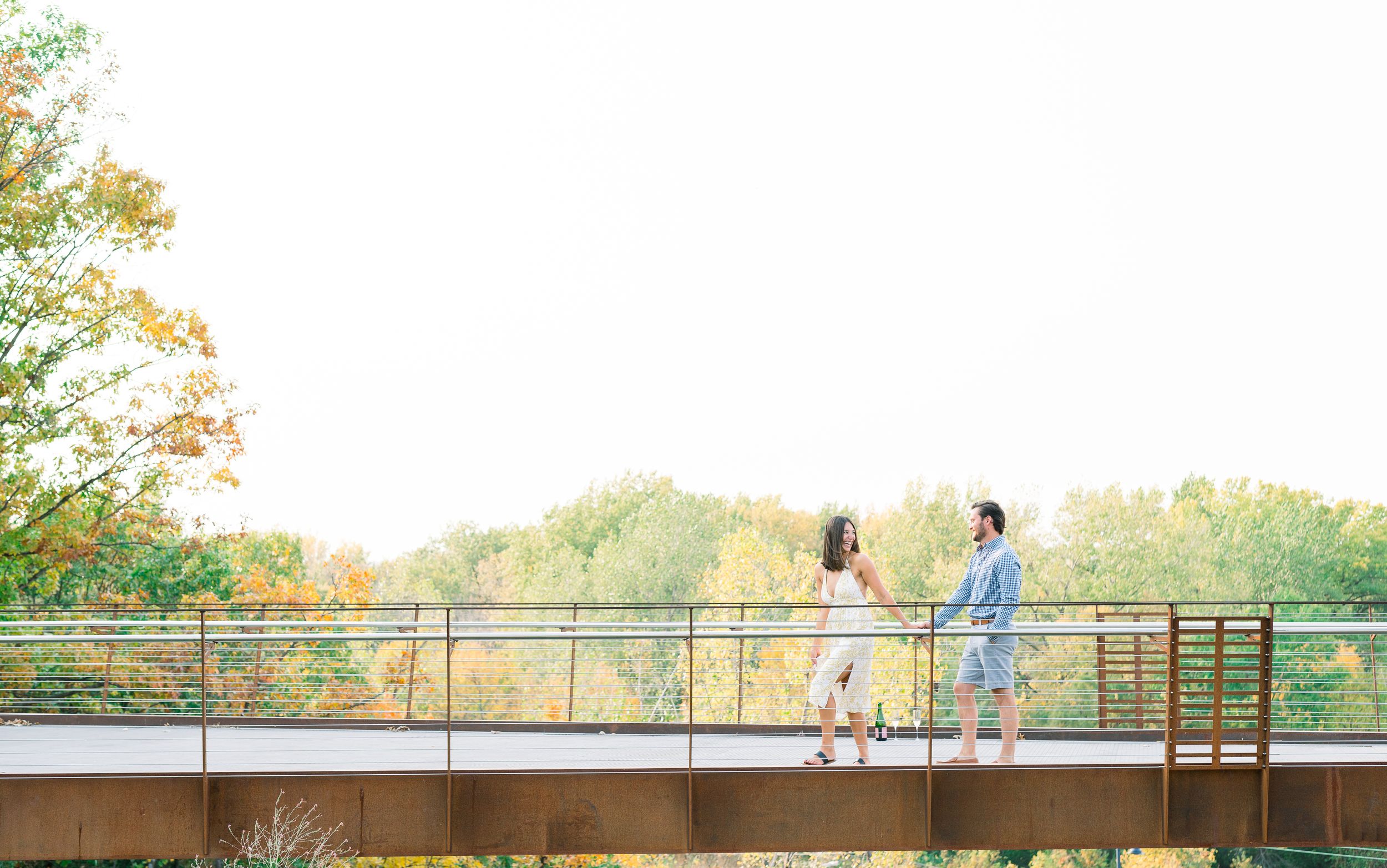 Des Moines Engagement photos with skyline of downtown Des Moines, Iowa with light and airy photographer Nicole Laing