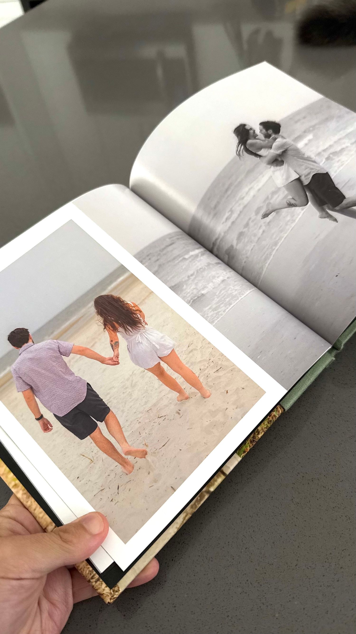 An open photo album showing romantic couple photographs in color and black and white.