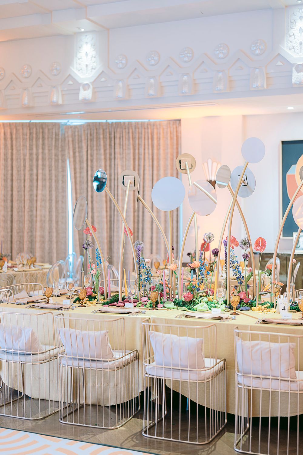 Elegant baby nursery with white cribs, floral arrangements, and soft lighting creating a sophisticated celebration setup.