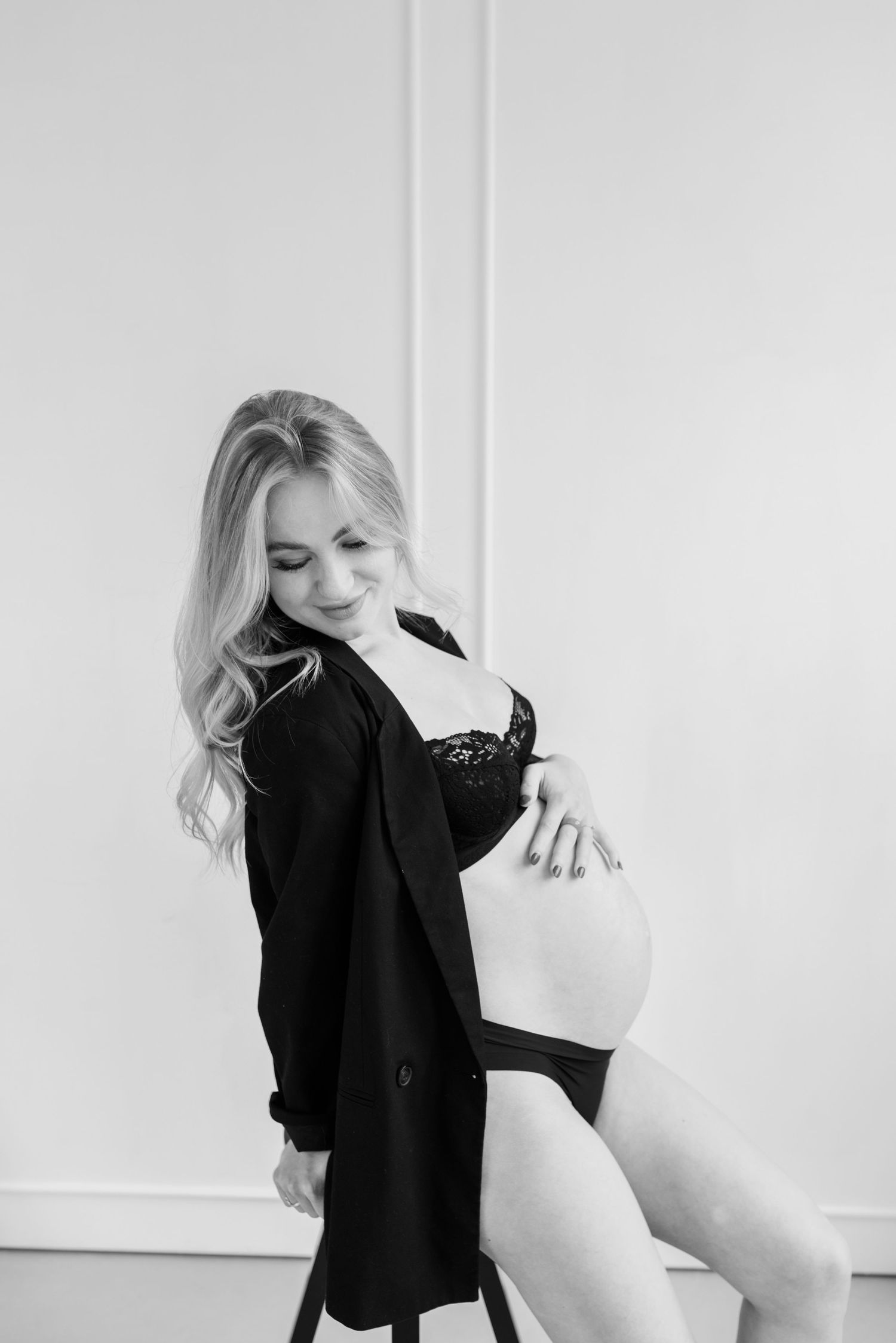 Black and white fashion portrait series showing a figure in a dark blazer posing against a white background.
