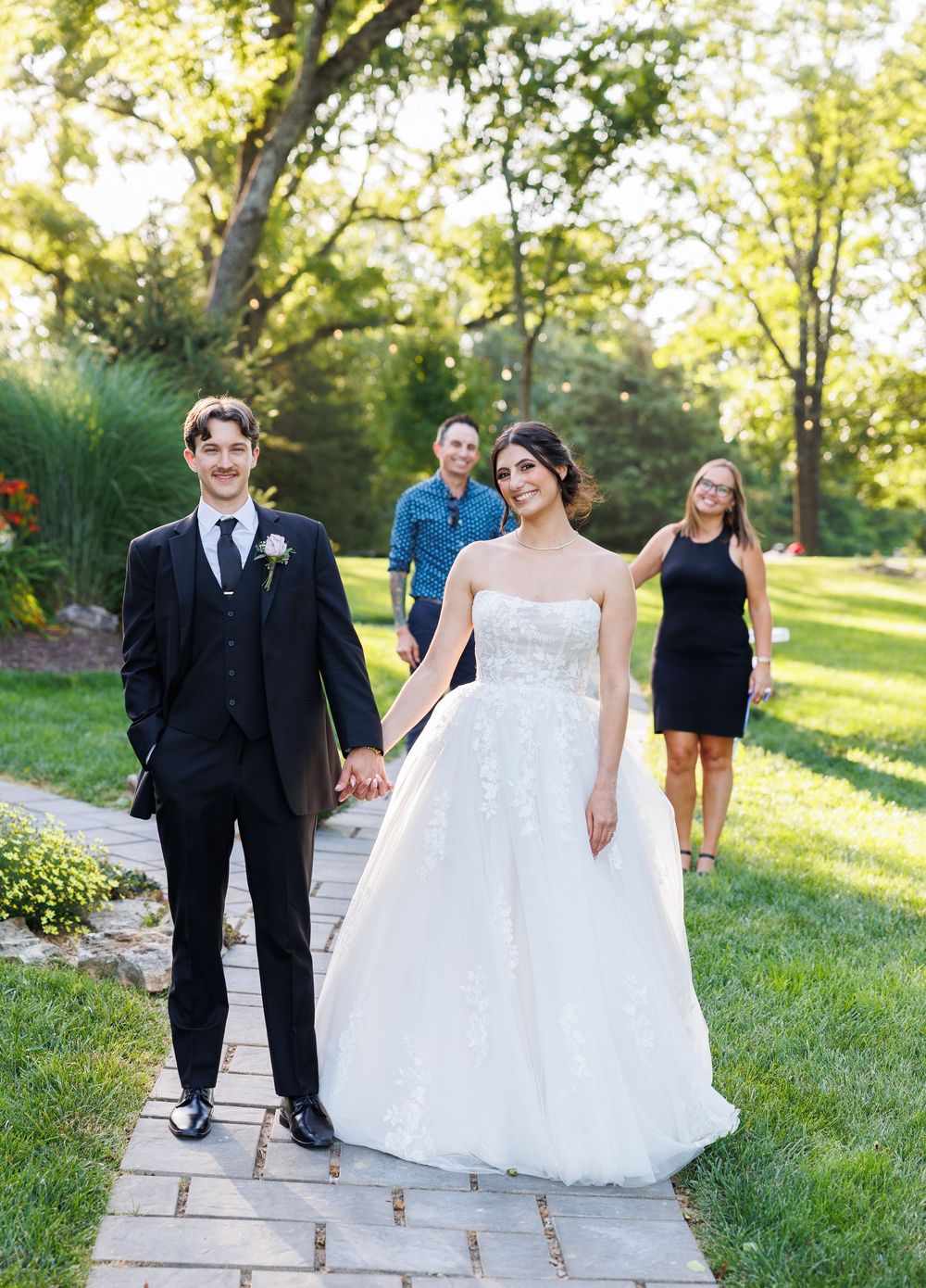 A sequence of five wedding photos on stone steps showing a couple and guests walking and posing in an outdoor garden setting.