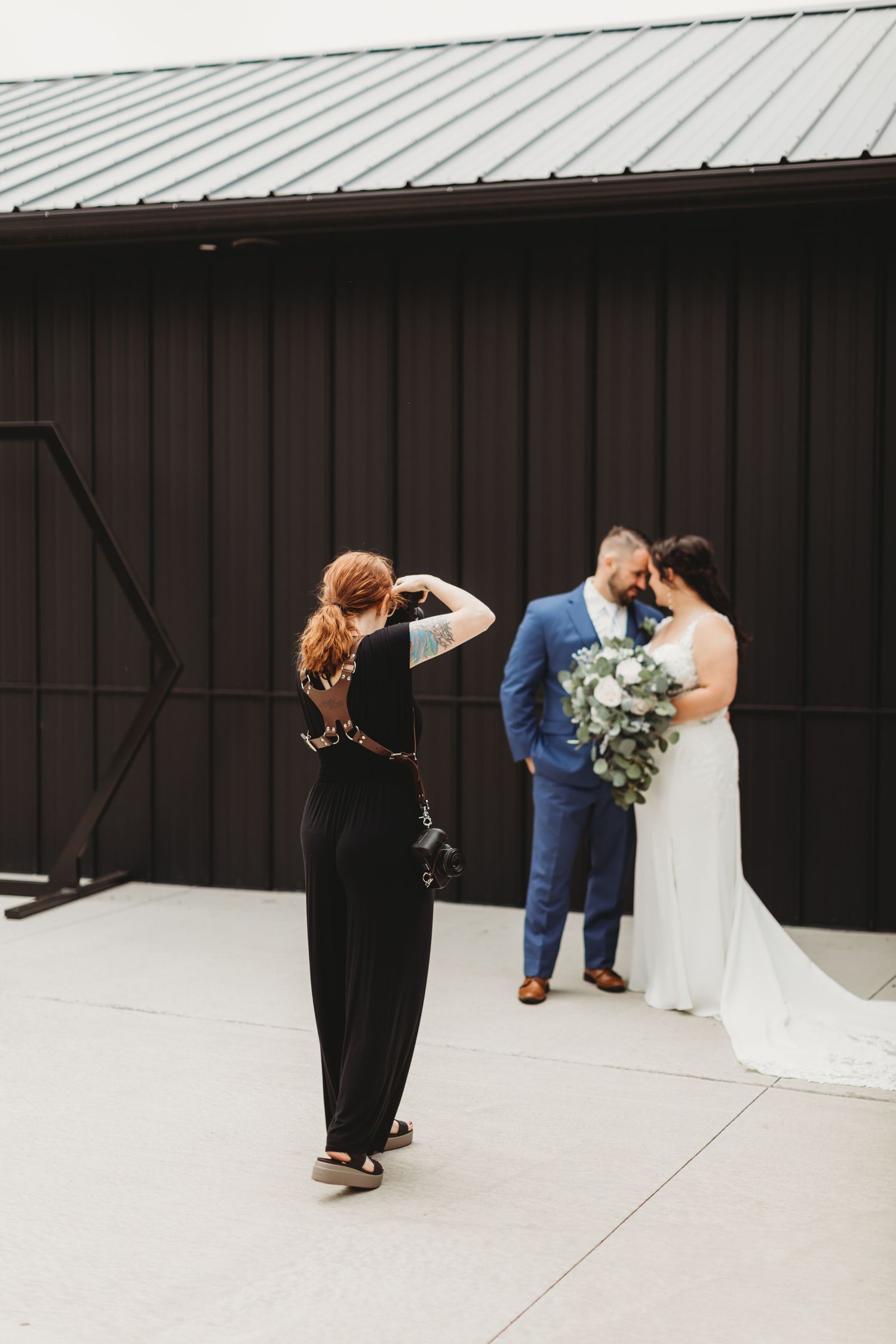 A sequence of six black and white wedding photos showing a couple taking romantic portraits against a modern wall.