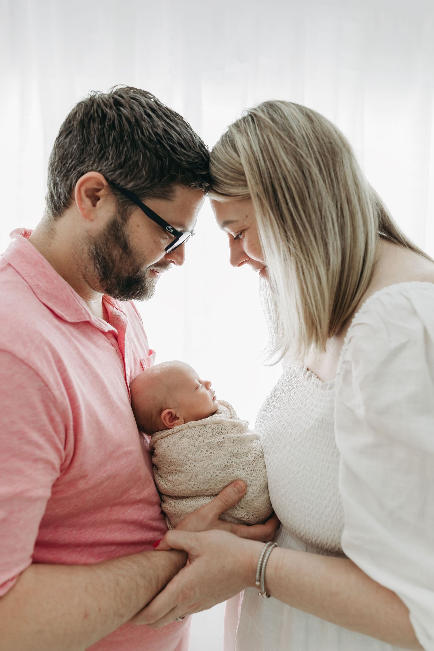 A series of intimate photos capturing tender moments between a parents and baby during newborn photos in Tampa
