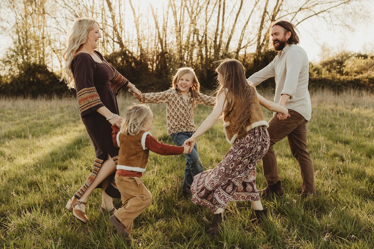 Group sitting together outdoors in a meadow during golden hour creating a joyful atmosphere in autumn.