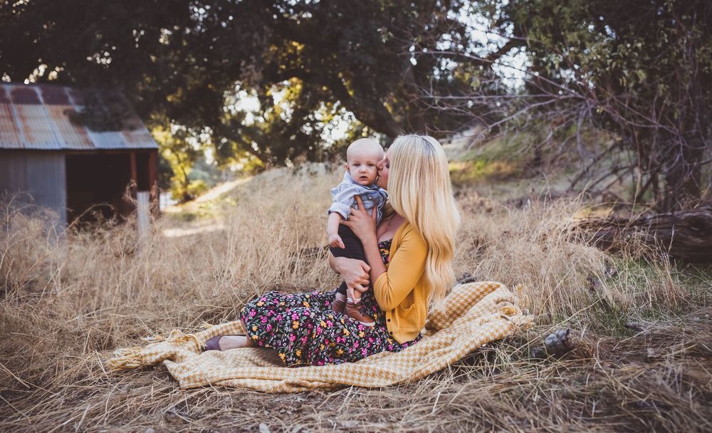 Panoramic view of family bonding outdoors during golden hour photo session in natural setting.