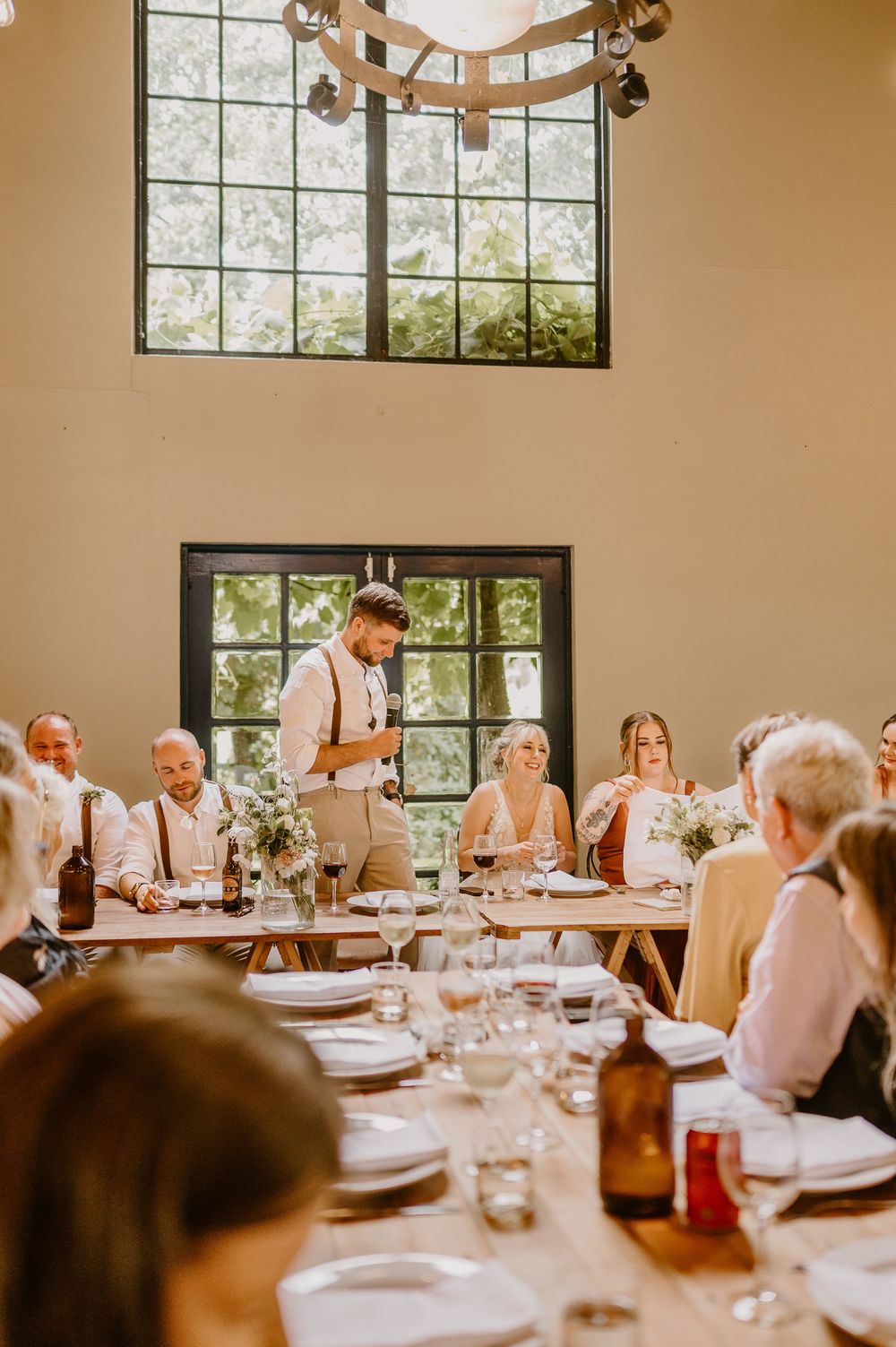 Reception table set for a wedding celebration with warm lighting and floral centerpieces.