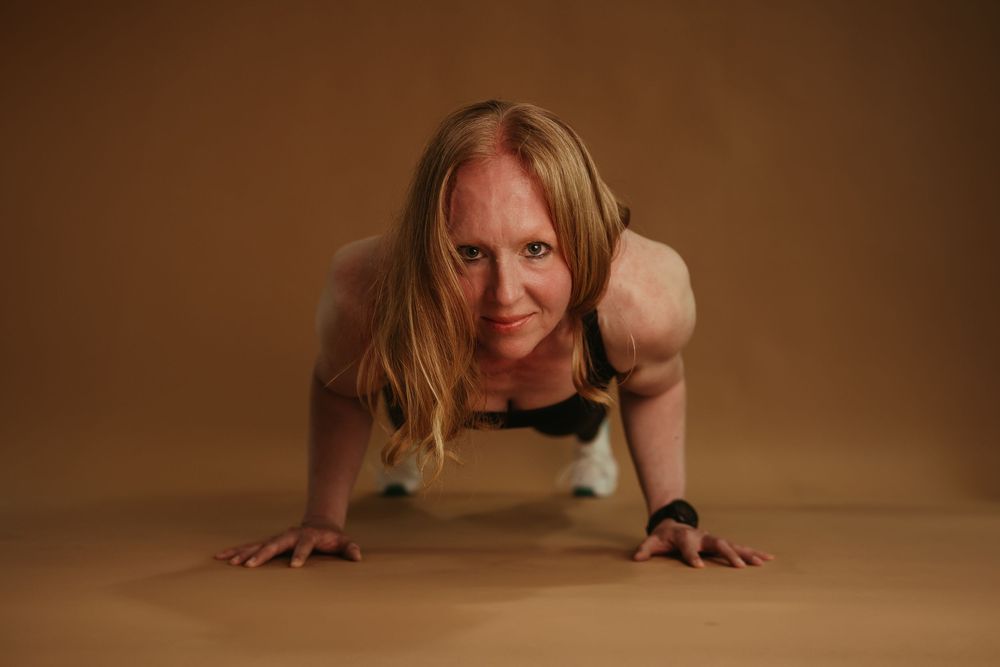 Person performing a dynamic plank exercise sequence on a warm-toned background in a fitness demonstration.