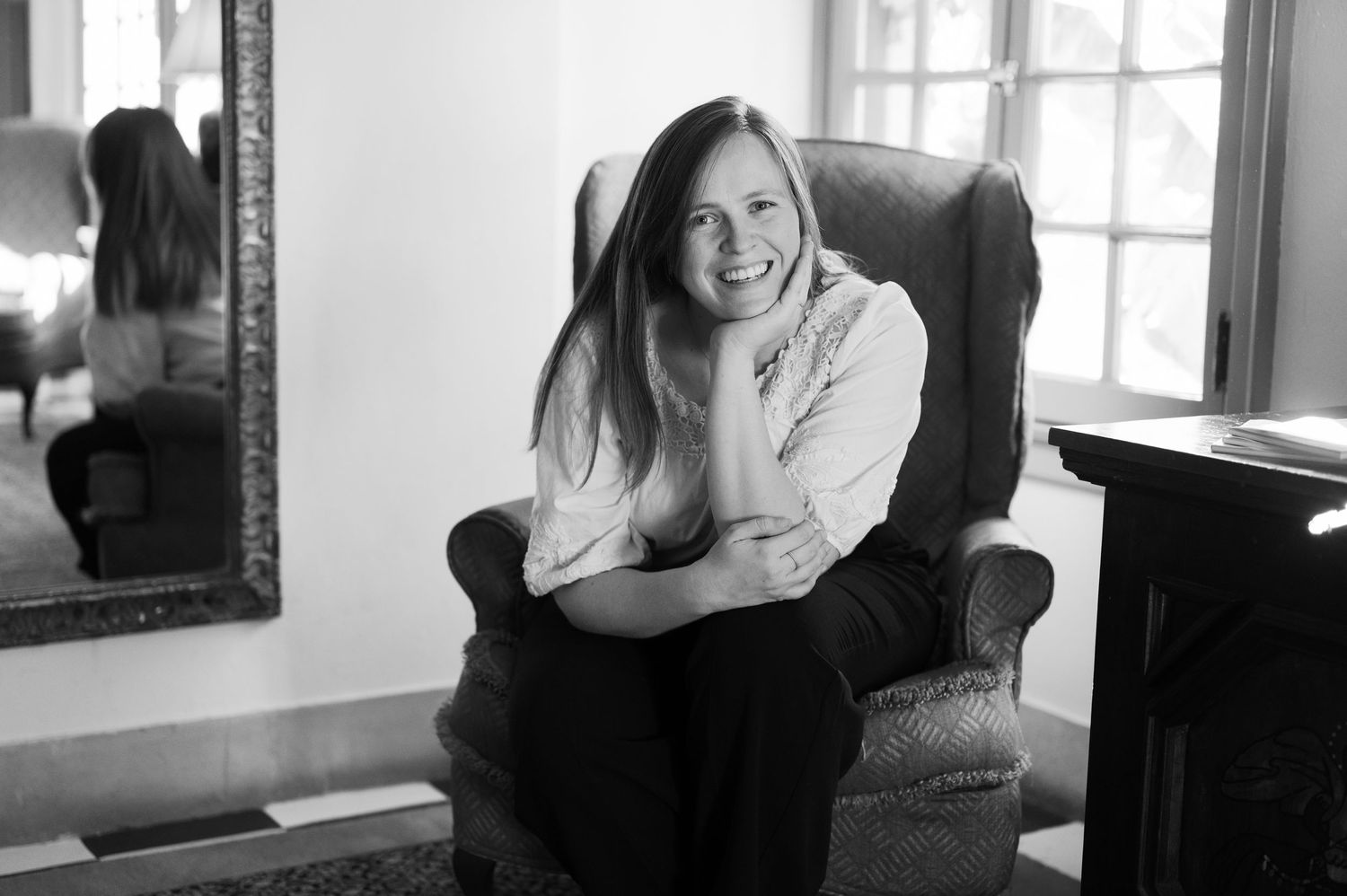 Emily Barrett, Jacksonville wedding photographer, smiling while sitting inside at Club Continental