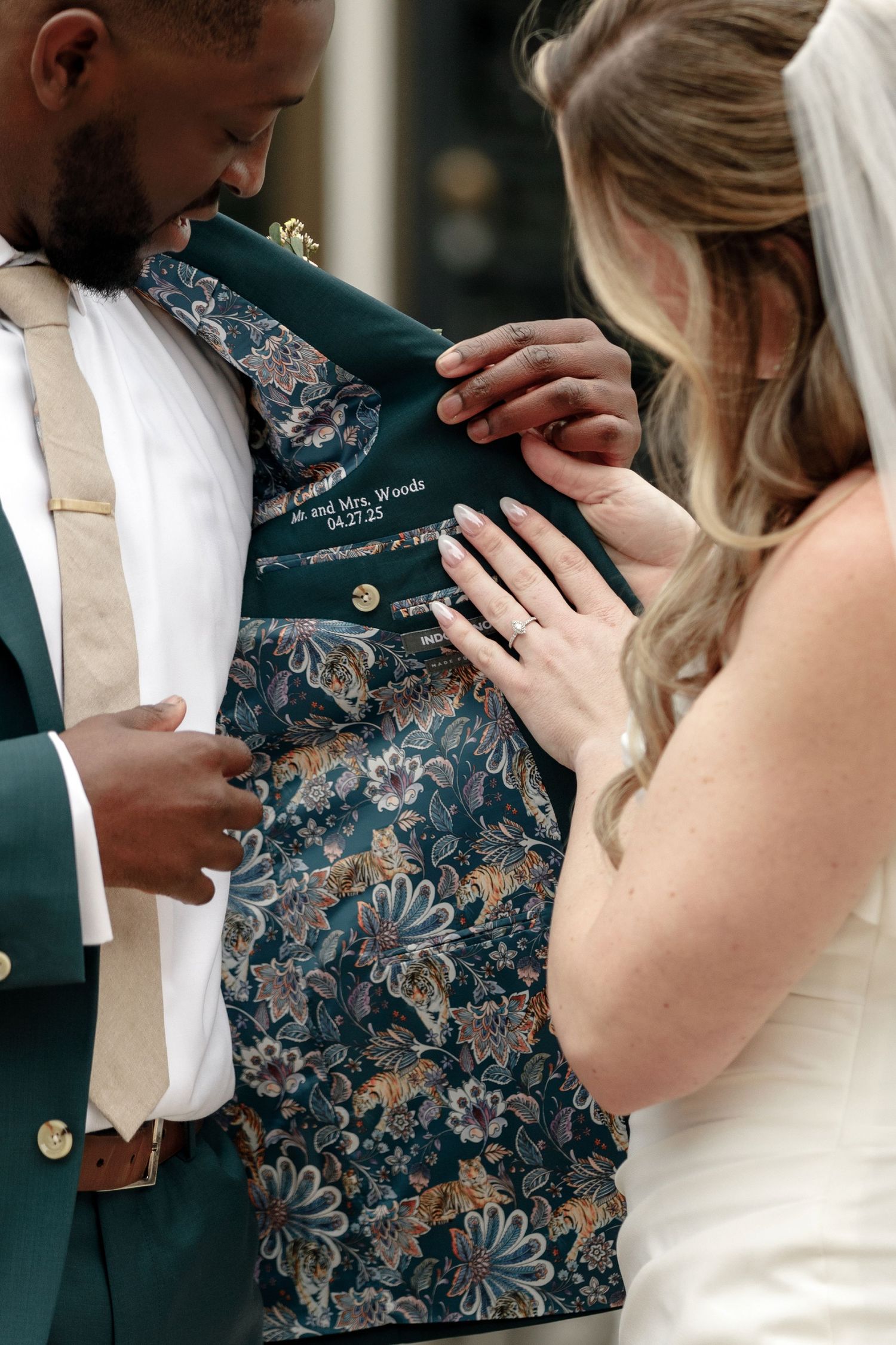 A close up of elegant floral patterned suit jacket lining being examined during a wedding photo session.