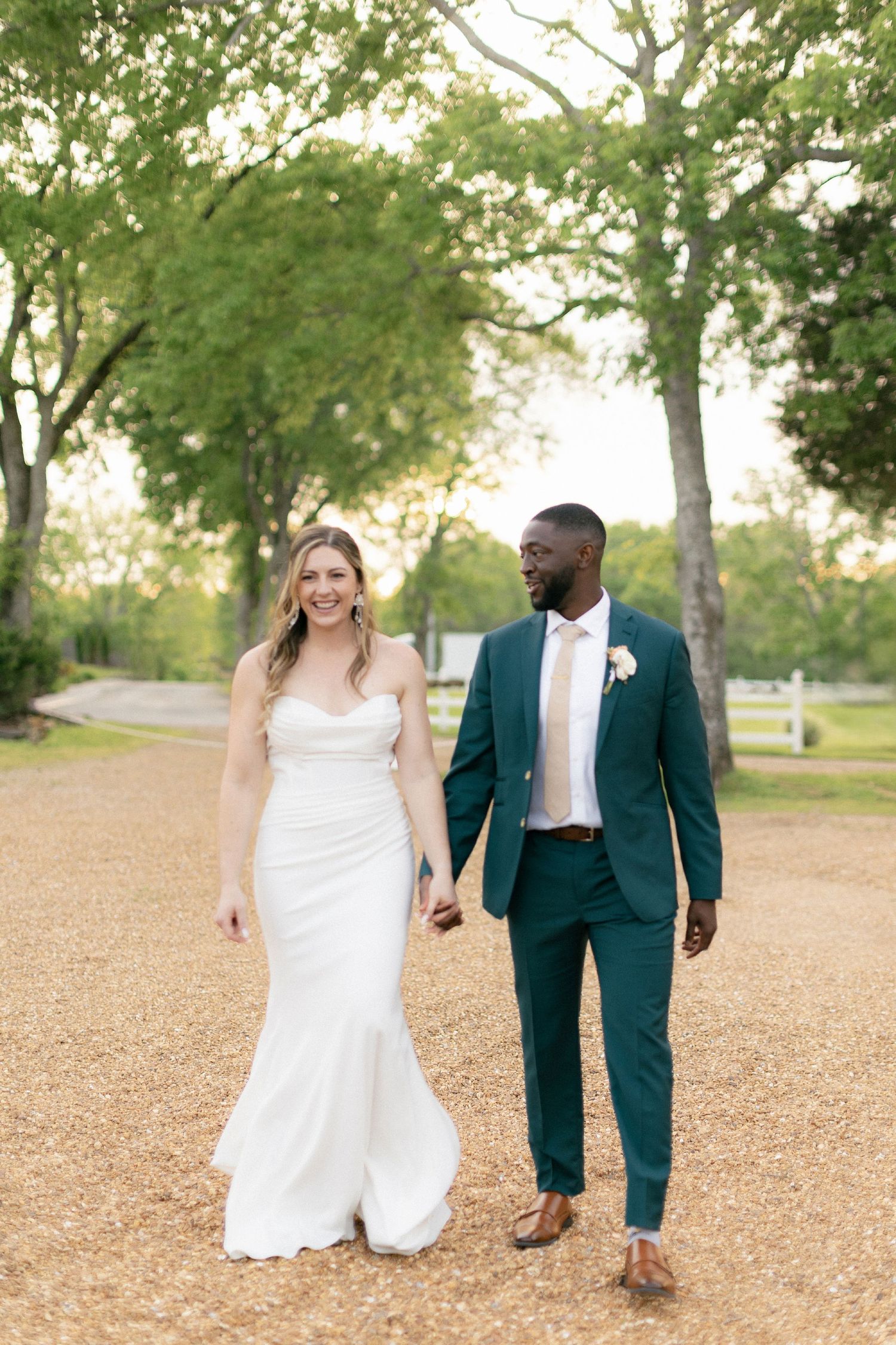 A couple in wedding attire walking together on a pathway at Legacy Farms near Nashville, TN.