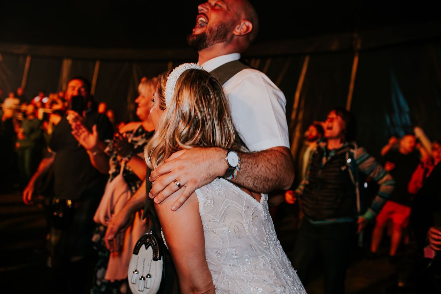Couple sharing an intimate embrace while dancing at an evening wedding reception.