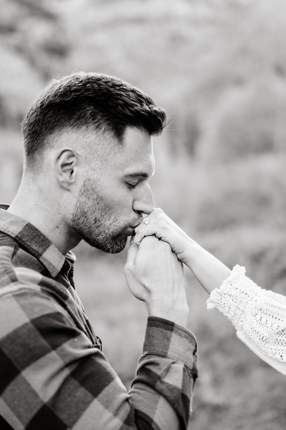 A tender moment captured in black and white against a mountainous backdrop.