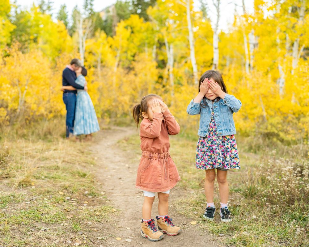Kids closing their eyes while mom and dad kiss at a spot at the Alpine Loop.