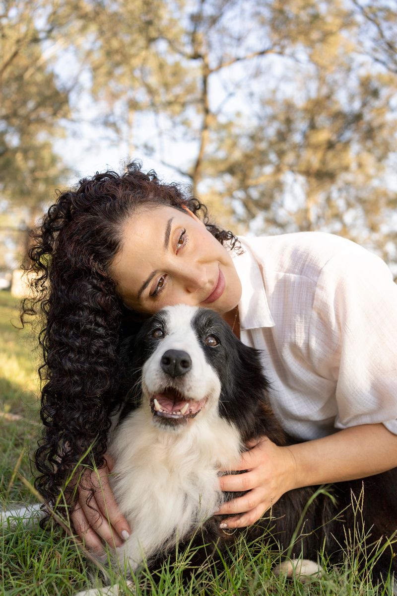 a border collie looking towards the camera while a girl hugging her during a photoshoot in Cattai