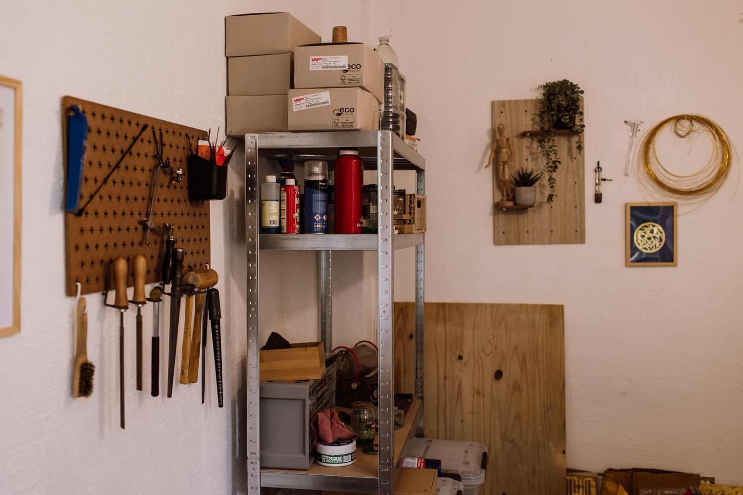 Organized workshop wall with pegboard storage displaying various tools and equipment on shelves.
