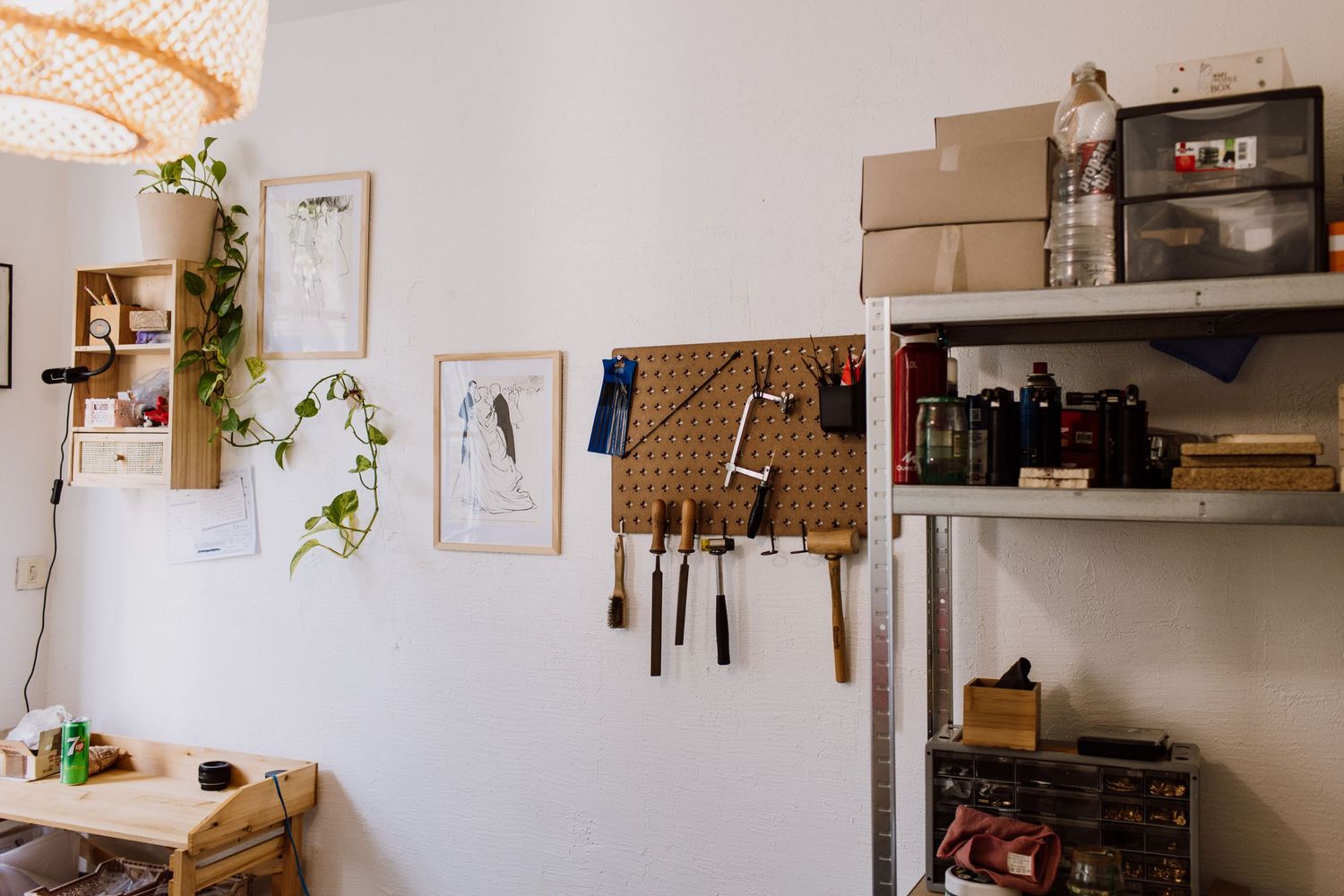 Artisan workspace with pegboard tool organization and decorative wall art in bright natural light.