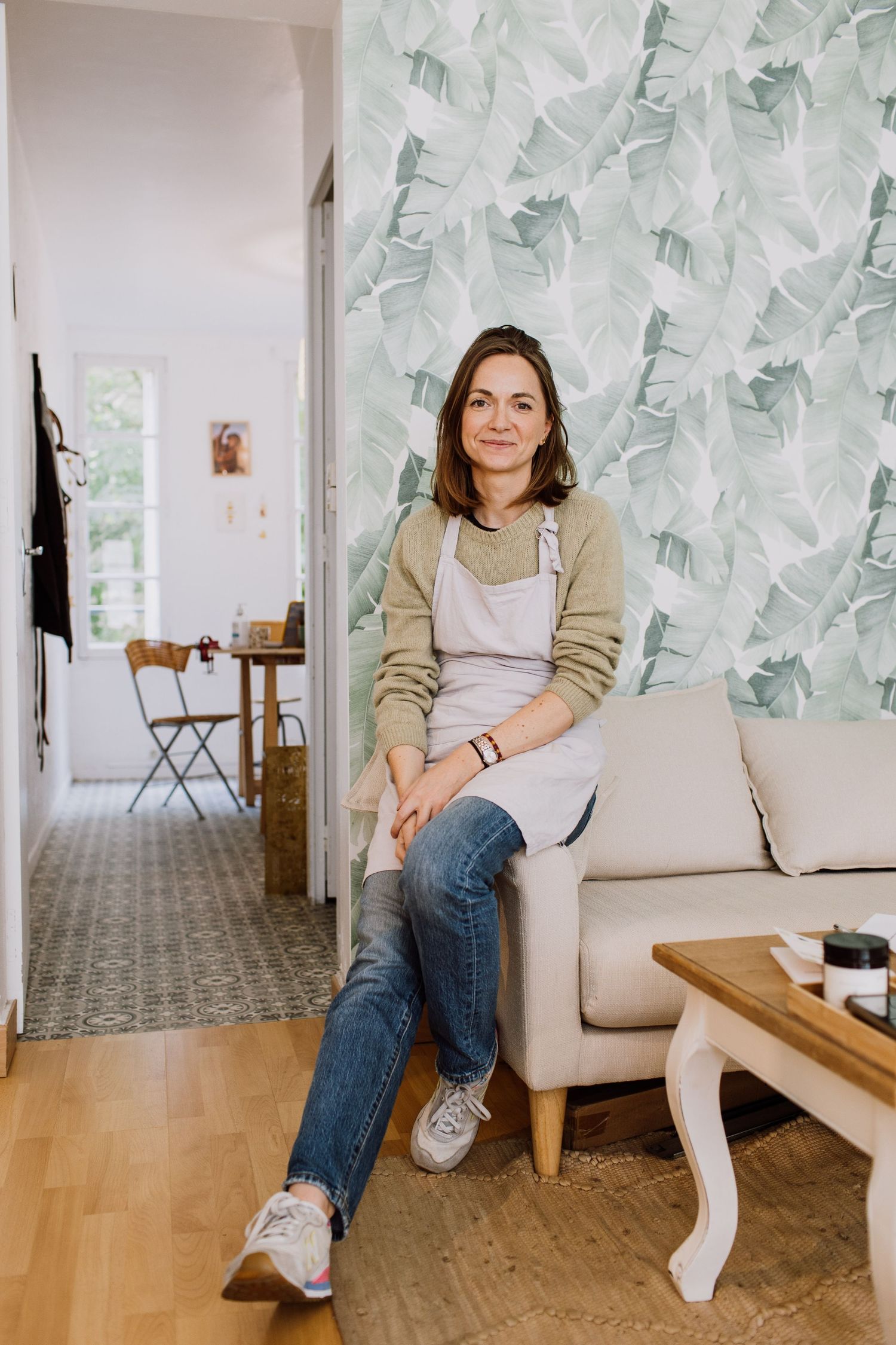 Workshop interior with leafy wallpaper featuring cozy seating area and hardwood floors.