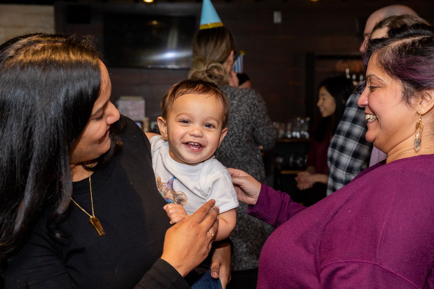 Joyful interaction at a birthday celebration with festive decor.