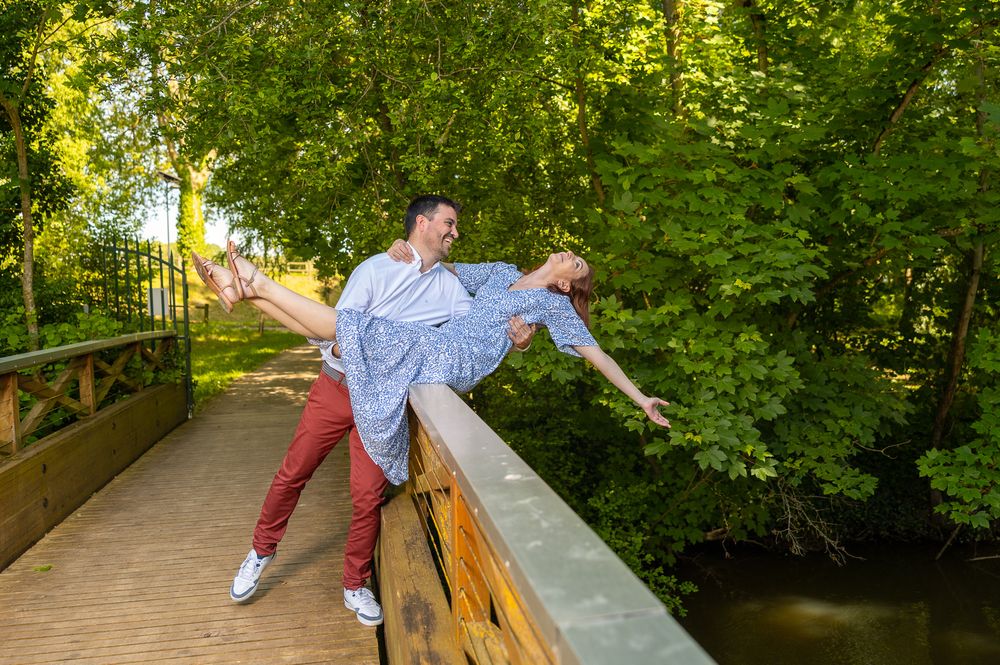 Person in white outfit performs graceful tai chi movements in a tranquil green garden setting.