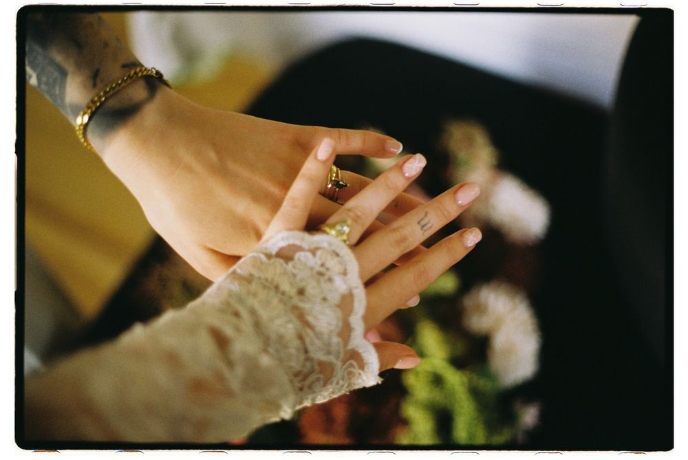 Close up of lace-adorned hands showing an engagement ring during a celebration.