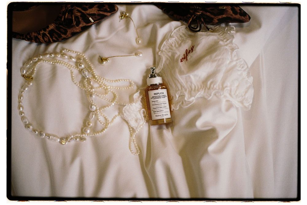 A collection of delicate white wedding dress details with lace trim and pearl embellishments.