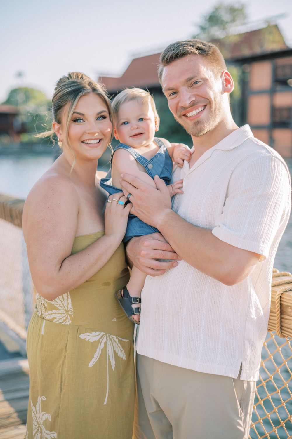 A waterfront family photo session featuring coordinated outfits and natural outdoor lighting.